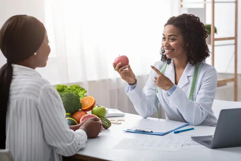 “Nutritionist explaining healthy diet plan with fruits during consultation – TDEE calculator disclaimer concept”
